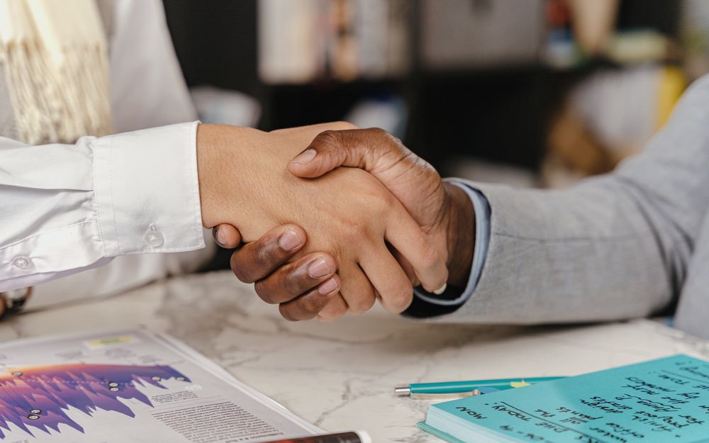 A handshake across the table as a deal closes