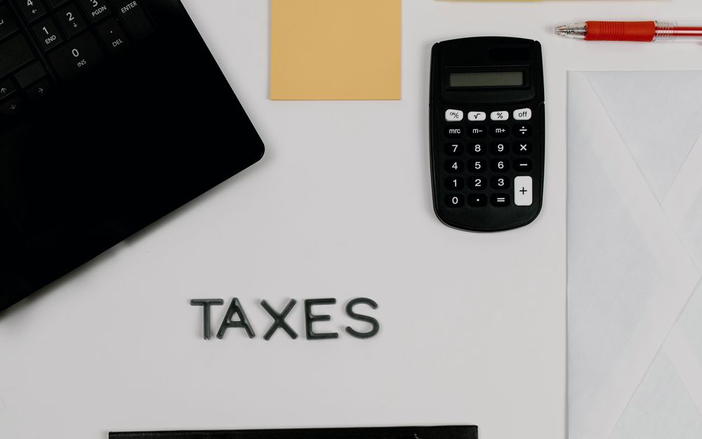 A tax workspace with calculator, notepad and documents